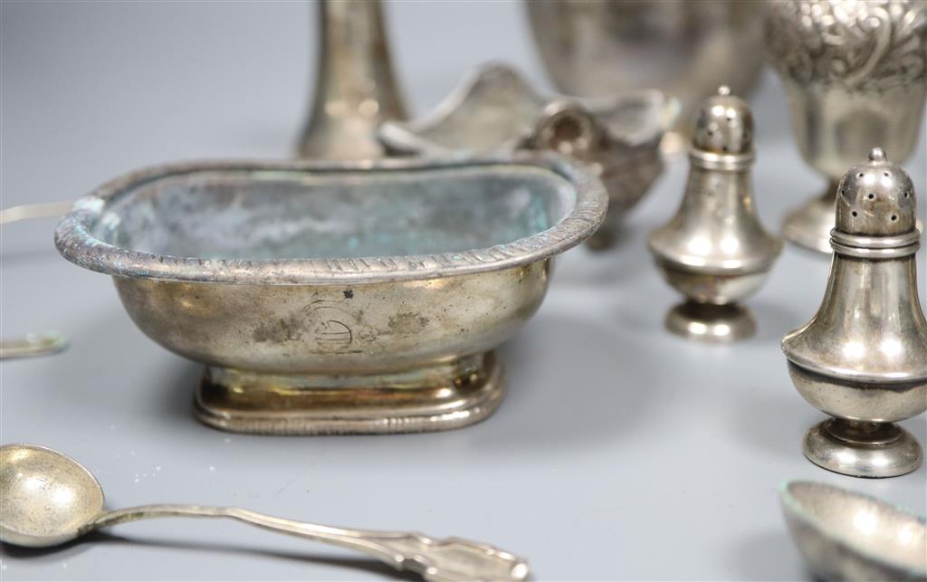 A George V silver cream jug and a collection of small silver and plated condiments and spoons.